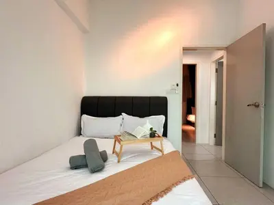 a bedroom with a bed with a table on it at JOVIAL Modern Cozy Homestay `Meritus Perai in Perai