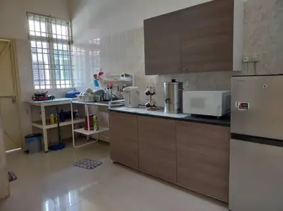 a kitchen with wooden cabinets and a refrigerator at Cheerful 3-Bedroom Residential Home with Free WIFI in Butterworth