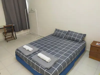 a bedroom with a blue bed with towels on it at Cheerful 3-Bedroom Residential Home with Free WIFI in Butterworth