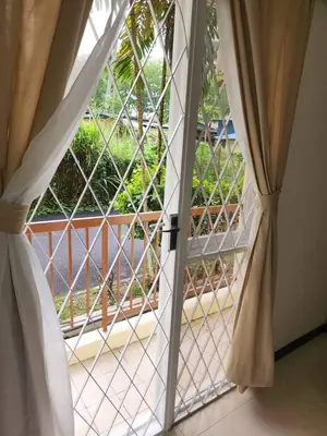 an open window with a view of a balcony at Have a pleasant stay with Bayu Emas Homestay in Batu Ferringhi