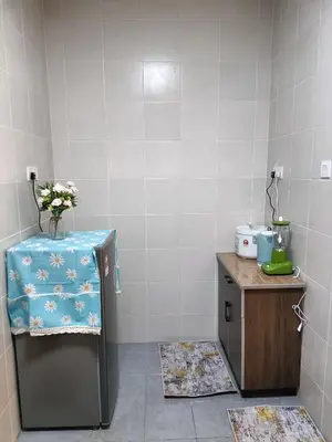 a kitchen with a table and a counter with flowers on it at Alyaleesya Emerald avenue 4 Brinchang for muslim in Brinchang