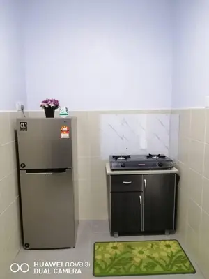 a small kitchen with a refrigerator and a stove at Alyaleesya homestay Emerald Avenue 1 Brinchang in Brinchang