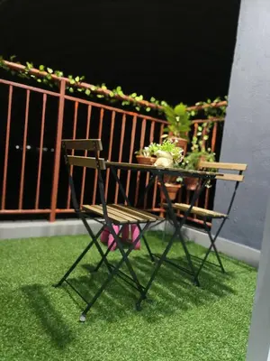 a chair and a table with plants on a balcony at Alyaleesya homestay Emerald Avenue 1 Brinchang in Brinchang