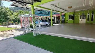 a playground in front of a house with a green building at Sri MaLati Homestay and Event Space in Balik Pulau