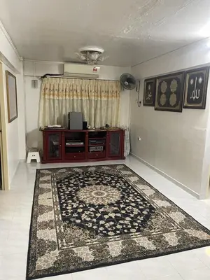 a living room with a red cabinet and a rug at Family House in Jelutong