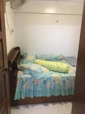 a small bed in a room with a bedspread on it at Family House in Jelutong