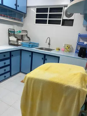 a kitchen with blue cabinets and a yellow table at Family House in Jelutong