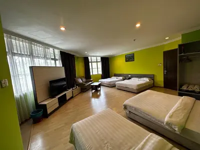 a large room with two beds and a flat screen tv at GOA INN HOTEL SDN BHD in Gua Musang