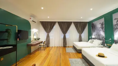a hotel room with two beds and a desk at Kimberley Boutique Hotel in George Town