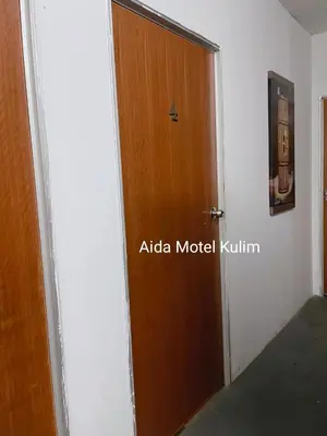 a wooden door in a room with a sign on it at Art Motel Kulim in Kulim