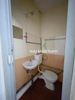 a bathroom with a toilet and a sink at Art Motel Kulim in Kulim