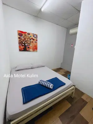 a bed in a room with a painting on the wall at Art Motel Kulim in Kulim