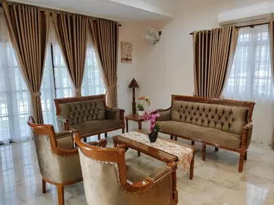a living room with couches and a table and chairs at Cs Villa Homestay in Ipoh