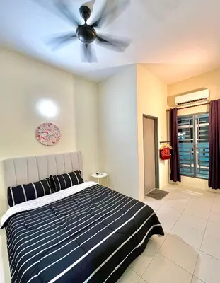 a bedroom with a ceiling fan and a bed at Homestay Akasia 12 in Seri Iskandar