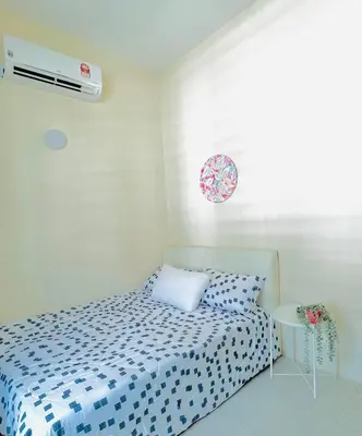 a small bedroom with a bed and a table at Homestay Akasia 12 in Seri Iskandar