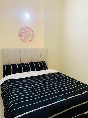 a bed in a bedroom with a pink clock on the wall at Homestay Akasia 12 in Seri Iskandar