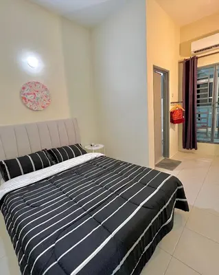 a bedroom with a black and white bed and a window at Homestay Akasia 12 in Seri Iskandar
