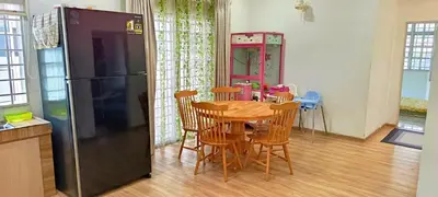 a kitchen with a table and a black refrigerator at Single Storey Bungalow 12 pax in Ipoh