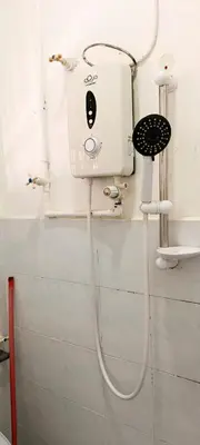 a shower in a bathroom with a hair dryer on the wall at Single Storey Bungalow 12 pax in Ipoh