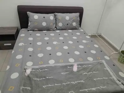 a bed with polka dot sheets and pillows in a room at Simple Home Taiping \u7b80\u5c45 @ Suria Aman in Kamunting