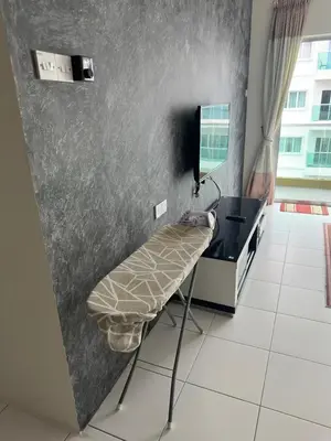 a room with a chair and a desk and a television at Family Stay at Quintet A2-7-3A in Tanah Rata