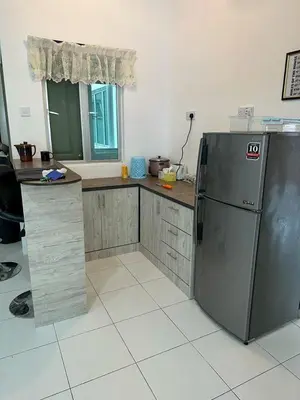 a kitchen with a refrigerator and a counter top at Family Stay at Quintet A2-7-3A in Tanah Rata