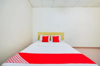 a red and white bed with red pillows in a room at CP Hotel in Butterworth