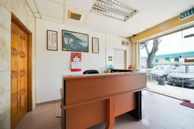 a wooden desk in a room with a window at CP Hotel in Butterworth