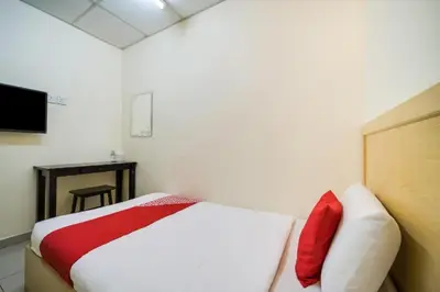 a bedroom with a bed with a red and white blanket at Hotel River Inn in Butterworth