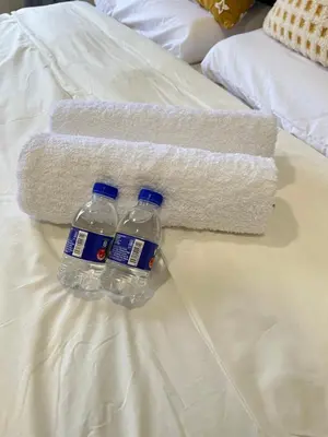 two bottles of water sitting on top of a bed at The Neighbour KKB - Rooms with shared bathroom - Whole unit has 4 rooms in Kuala Kubu Baharu