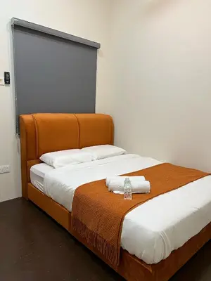 a bed with a wooden headboard with a towel on it at The Neighbour KKB - Rooms with shared bathroom - Whole unit has 4 rooms in Kuala Kubu Baharu