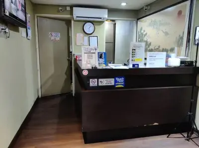 a lobby with a counter with a clock on the wall at Juru Hotel in Bukit Mertajam