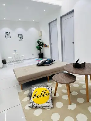a living room with a couch and two tables at Inn Homestay in Teluk Intan
