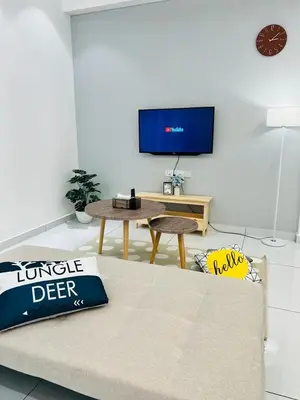 a living room with a bed and a table and a tv at Inn Homestay in Teluk Intan