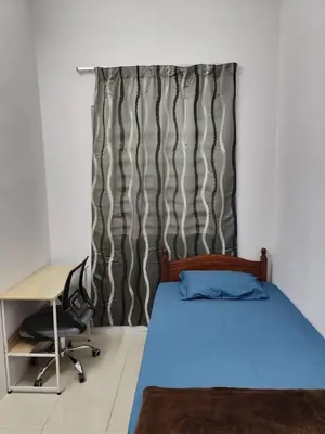 a bedroom with a bed and a desk and a curtain at YMT Tambun The Lost World Hideaway in Ipoh