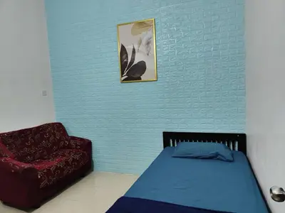 a bedroom with a bed and a red chair at YMT Tambun The Lost World Hideaway in Ipoh