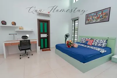 a bedroom with a blue bed and a desk at Qua Homestay 5 Rooms 6 Bathrooms in Taiping