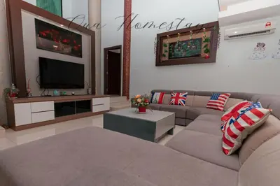 a living room with a couch and a flat screen tv at Qua Homestay 5 Rooms 6 Bathrooms in Taiping