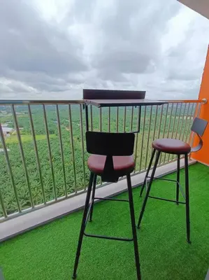 a desk and two chairs sitting on a balcony at Joyful Sitiawan skygarden swimming pool in Seri Manjung