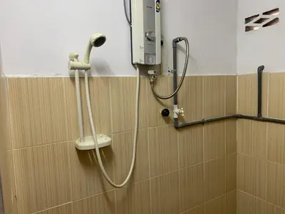 a shower in a bathroom with a hose on a wall at D’baroh Homestay in Kampong Tanjong Karang
