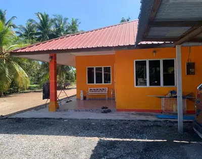 a small orange house with a red roof at D’baroh Homestay in Kampong Tanjong Karang