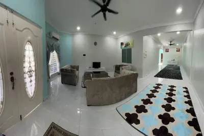 a living room with a ceiling fan and a couch and a rug at Casa Indera in Kampung Bota Kiri