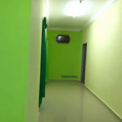 a green room with a green wall and a television at Hijau Homestay in Sungai Besar