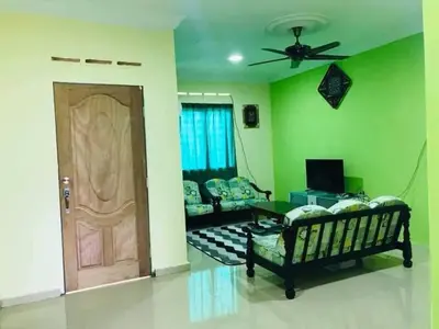 a living room with green walls and a wooden door at Hijau Homestay in Sungai Besar
