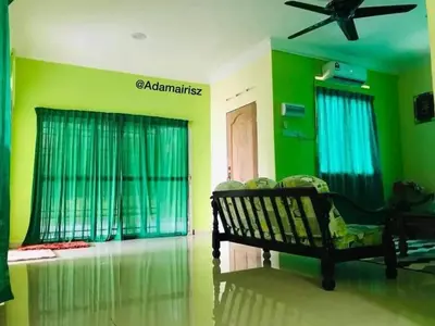 a living room with a bench and green walls at Hijau Homestay in Sungai Besar