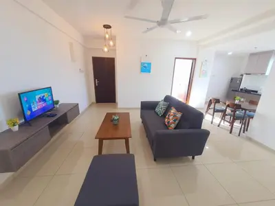 a living room with a couch and a tv and a table at LOVELY 2ROOM SUITE6PAX@SKY CONDO JURU SENTRAL in Bukit Mertajam