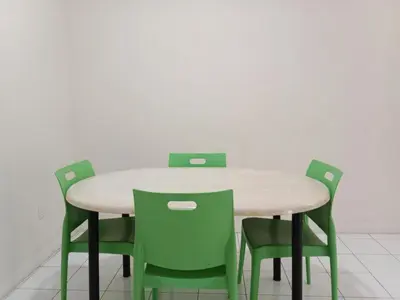 a table with four green chairs in a room at CLP perai homestay near Sri Muniswarar Temple 2 in Perai
