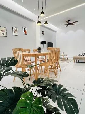 a living room with a table and chairs and a plant at Inn Homestay 1st Floor Unit in Teluk Intan