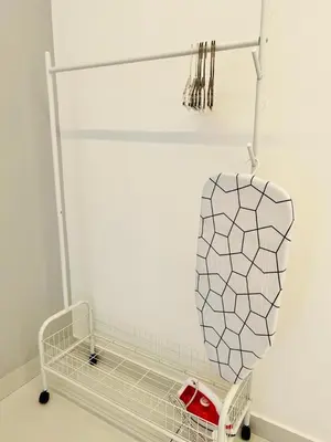 a white room with a towel rack and an umbrella at Inn Homestay 1st Floor Unit in Teluk Intan