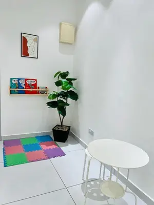 a white room with a table and a potted plant at Inn Homestay 1st Floor Unit in Teluk Intan